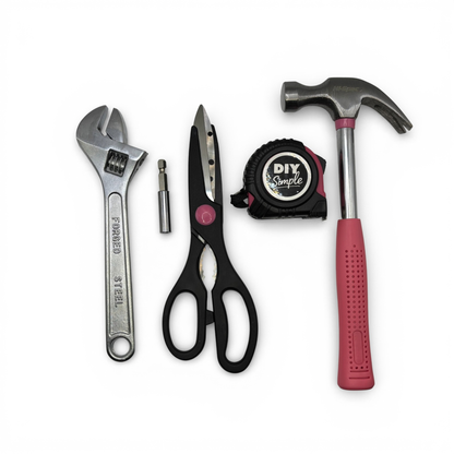 A set of four DIY hand tools on a white background: a silver adjustable wrench, black-handled scissors, a black tape measure labeled DIY Simple, and a hammer with a red handle.