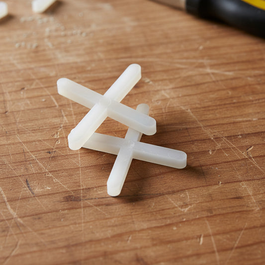 Pack of 100 white DIY Simple LTD 3mm X-shaped tile spacers used for precise tiling and grout joint spacing.